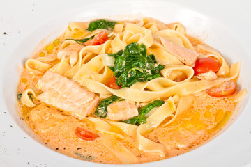 tasty pasta with cream, salmon, cheese and parsley close up