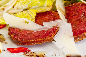 Salad from fried sausages, lettuce with sour cream sauce