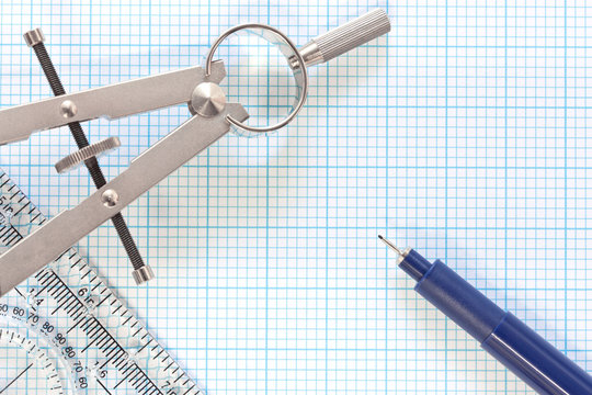 Engineering graph paper with compass and pen