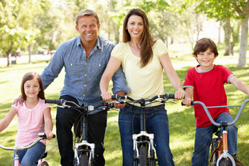 Obraz premium Family riding bikes in park