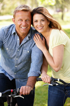 Couple riding bikes in park