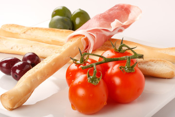 Antipasto con grissini, prosciutto, olive e pomodori