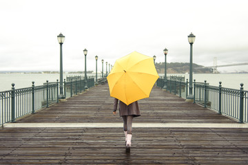 girl walking with umbrella - obrazy, fototapety, plakaty