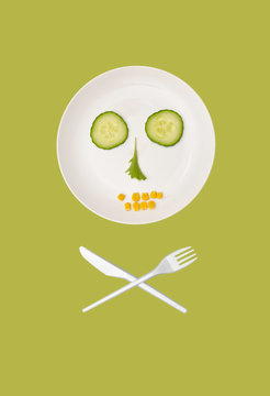 a plate with vegetables in the shape of skull and bones