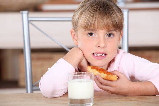 Little girl with jam and milk