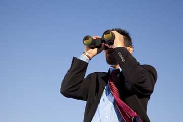Businessman searching with his binoculars
