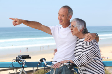 Senior couple having bike ride at the beach