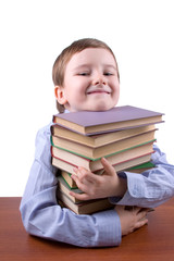 Happy boy hugging a pile of books