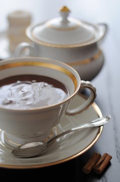 Cioccolata calda con cannella in tazza bianca e canestrelli