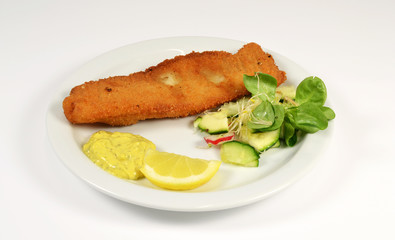 Fish with lemon and salad on a white context.