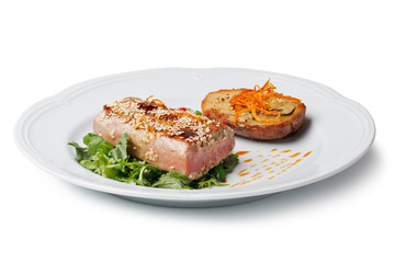 Fried tuna steak and potatoes on the plate