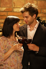 Young Couple in Bodegas, holding wineglasses, fallen in love