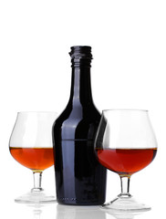 Glasses of brandy and bottle isolated on white