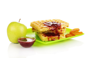 Tasty waffles with jam on plate isolated on white