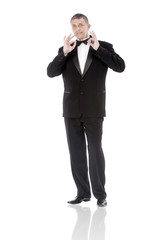 Obraz premium The elegant man in a classical tuxedo on a white background