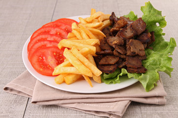 plate of meat, french fries and vegetables