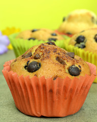 Home made chocolate chip muffins on a wooden board