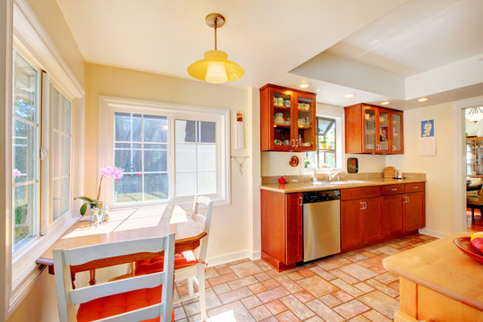 Charming Cherry Wood Kitchen With Tile Floor.