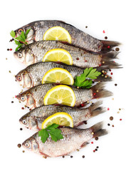 Fresh fishes with lemon, parsley and spice isolated on white