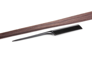Shiny brown hair and comb isolated on white
