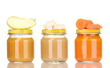 Jars of baby puree with spoon isolated on white
