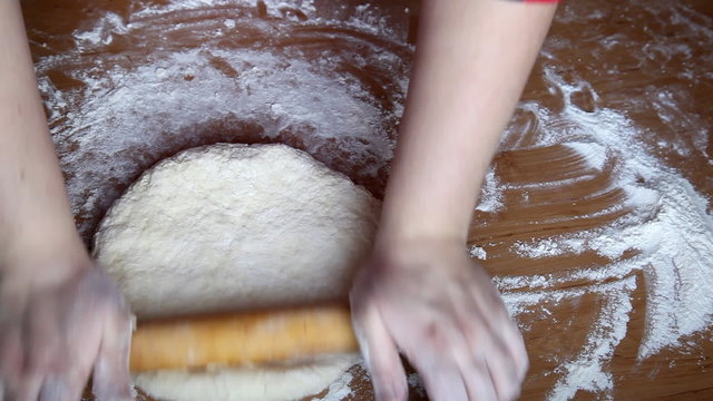woman rolling pastry with a rolling pin