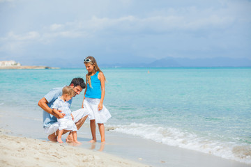Fototapeta na wymiar Father with her two kids on beach vacation
