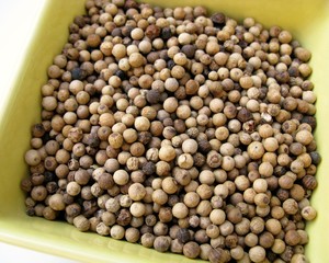 An assortmet of pepper corns in a yellow bowl