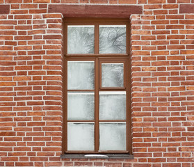 Window covered with frostwork in a brick wall