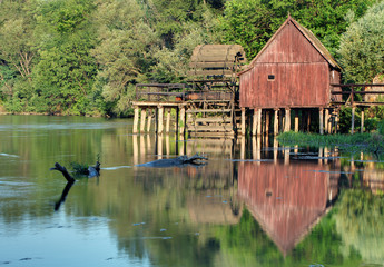 Fototapeta na wymiar Historic wooden watermill with reflection.