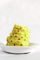Sliced pineapple on a white plate