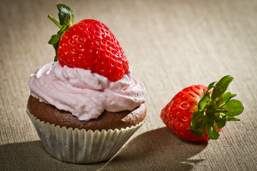Chocolate muffin with strawberry and sweet cream