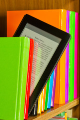 Row of colorful books and electronic book reader