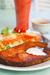 grilled salmon steak with cherry tomatoes and salad