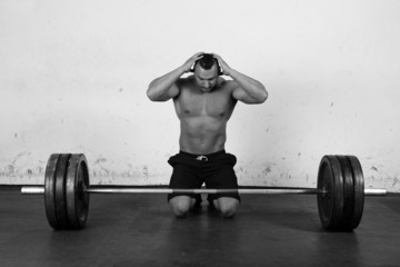 An athlete is preparing to lift a heavy dumbbell