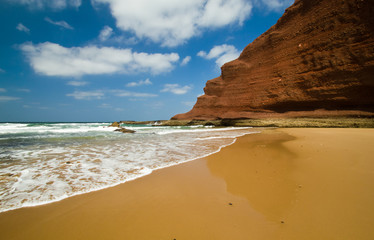 huge red cliffs on the beach Legzira. Morocco