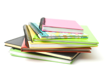 Colourful books stacked on a white background.