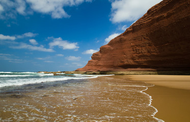 huge red cliffs on the beach Legzira. Morocco