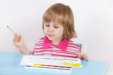 The little girl draws paints