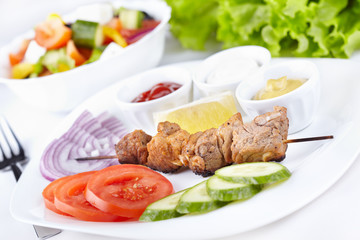 Kebab with fresh vegetables and greek salad