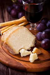 Pecorino with Red Grapes and Wine on Wooden Board