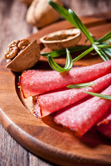 Spicy Salami with Rosemary on Wooden Board