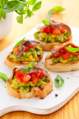 crostini with avocado,tomato and anchovy