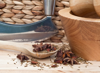 Star Anise and cumin seeds in rustic kitchen setting with wooden