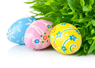 Easter eggs in the green grass isolated on white background