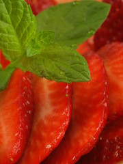 Macro of sliced strawberries with leaf of mint