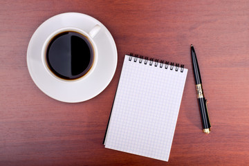 Cup of coffee, notebook and pen