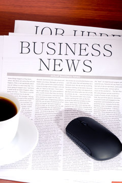 Business newspaper, cup of coffee and mouse