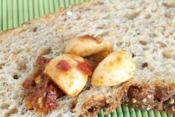 spicchi d'aglio sott'olio su fetta di pane ai cereali