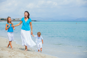 Mother and two kids having fun on beach